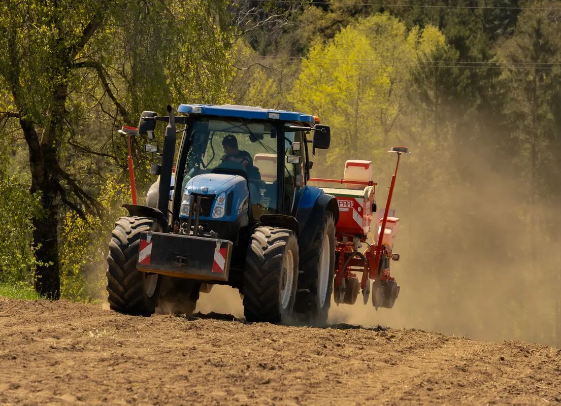 Traktor mit Sämaschine im Staub